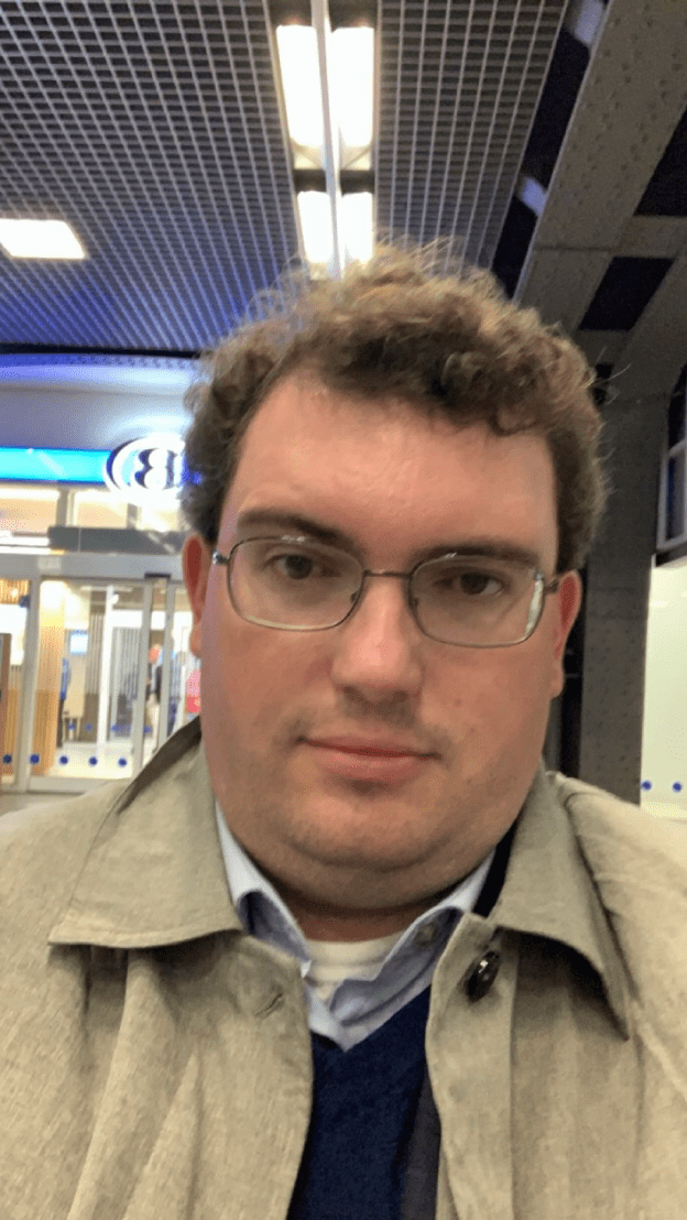 The author sitting in a railway station in Belgium looking tired after a transatlantic flight.